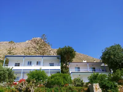 an apartment building in front of a mountain at Milios Studios in Megálon Choríon