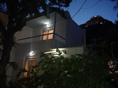 a white house with lights in the night at Milios Studios in Megálon Choríon