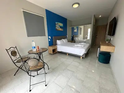a bedroom with a bed and a table and chair at Ayit Hotel in Theologos