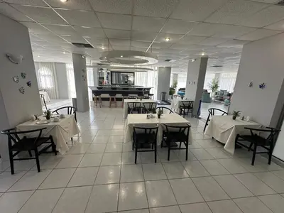 a restaurant with tables and chairs in a room at Ayit Hotel in Theologos