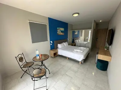 a bedroom with a bed and a table and chairs at Ayit Hotel in Theologos