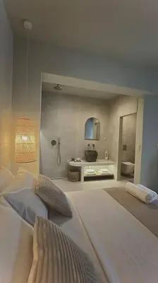 a white room with a bed and a bathroom at Hacienda tradition&relax in Afantou