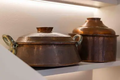 two old copper pots sitting on a shelf at Casa Alizeta in Halki