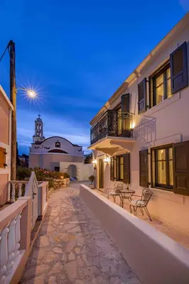 a house with a balcony and a building with a lighthouse at Casa Alizeta in Halki