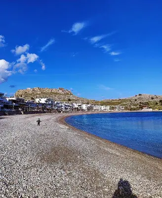 a person standing on a beach near the water at Flora's Traditional House in Malona Village