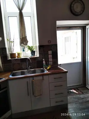 a kitchen with a sink and two windows at Flora's Traditional House in Malona Village