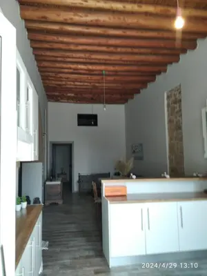 a kitchen with white cabinets and a wooden ceiling at Flora's Traditional House in Malona Village