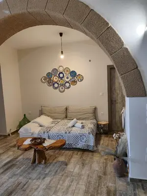 a bedroom with a bed and a table with plates on the wall at Flora's Traditional House in Malona Village