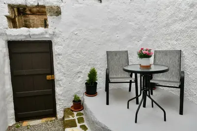 a patio with two garage doors and a table and two chairs at PENELOPE garden house old town in Rhodes Town