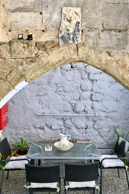 a table with a teapot on it next to a stone wall at PENELOPE garden house old town in Rhodes Town