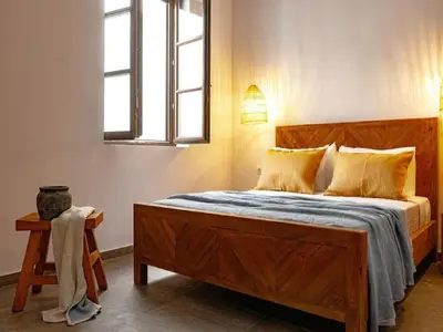 a bedroom with a large wooden bed with a window at Exquisite Rhodes Villa Villa Boho Chic 6 Bedrooms Private Pool in Lachania