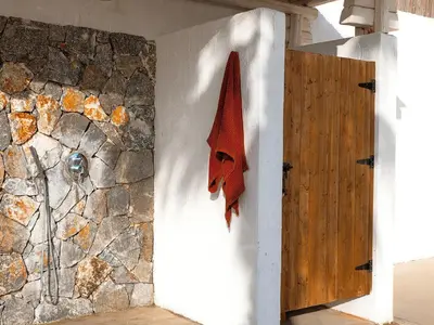 a red mask on a wall next to a stone wall at Exquisite Rhodes Villa Villa Boho Chic 6 Bedrooms Private Pool in Lachania