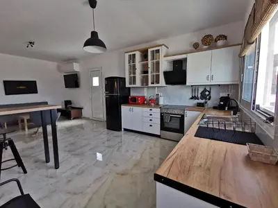 a kitchen with white cabinets and a black refrigerator at Mika's B luxury House near Faliraki in Kalithies