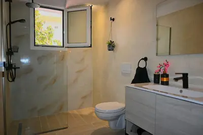 a bathroom with a sink and a toilet at Mika's B luxury House near Faliraki in Kalithies