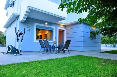 a patio with chairs and a table in front of a house at Diamond Rod Villa near Faliraki in Kalithies