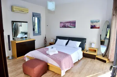 a bedroom with a large bed and a mirror at Diamond Rod Villa near Faliraki in Kalithies