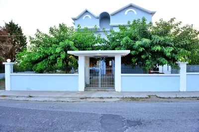 a white building with a gate in front of it at Diamond Rod Villa near Faliraki in Kalithies