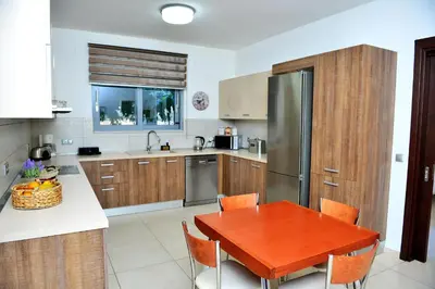 a kitchen with a wooden table and a refrigerator at Diamond Rod Villa near Faliraki in Kalithies