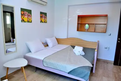 a small bedroom with a bed and a mirror at Diamond Rod Villa near Faliraki in Kalithies