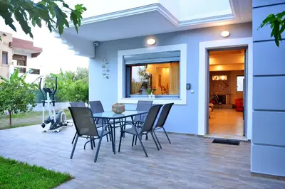 a patio with a table and chairs in front of a house at Diamond Rod Villa near Faliraki in Kalithies
