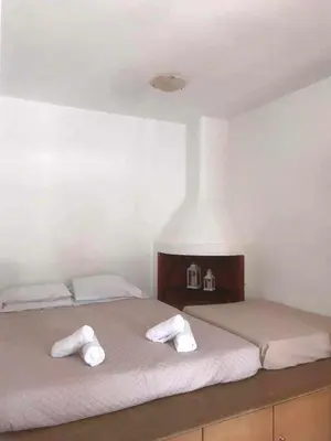 two beds in a white room with towels on them at Dimitras Studio in Arnítha
