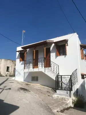 a white house with a balcony on a street at Dimitras Studio in Arnítha