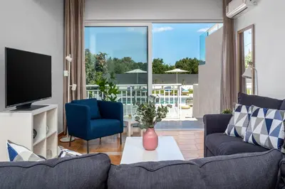 a living room with a couch and a tv at Eternity Villa Kolympia in Kolimbia