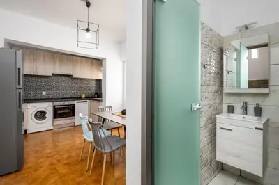 a kitchen with white cabinets and a table and chairs at Eternity Villa Kolympia in Kolimbia
