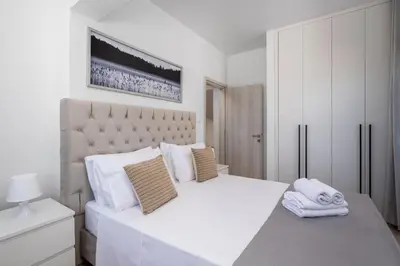 a white bedroom with a large bed with towels on it at Eternity Villa Kolympia in Kolimbia