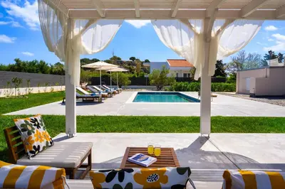 a backyard with a pool and a pergola at Eternity Villa Kolympia in Kolimbia
