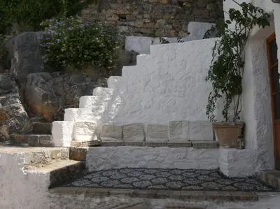a white stone staircase with a potted plant on it at Lindos Traditional House in Rhodes Town
