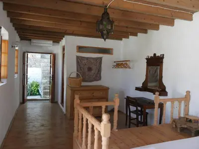 a living room with a table and a wooden ceiling at Lindos Traditional House in Rhodes Town