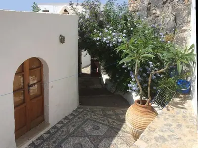 a plant in a large vase next to a door at Lindos Traditional House in Rhodes Town
