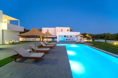 a swimming pool with lounge chairs and a house at Villa Marina - Glystra Beach in Kiotari