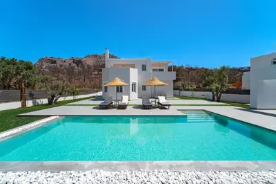 a villa with a swimming pool in front of a house at Villa Marina - Glystra Beach in Kiotari