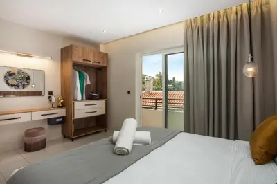 a bedroom with a large bed and a balcony at JnS Premium Stay in Faliraki