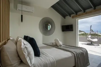 a bedroom with a bed and a sliding glass door at JnS Premium Stay in Faliraki
