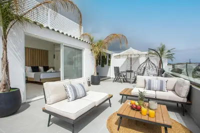 a patio with two couches and a table with fruit on it at JnS Premium Stay in Faliraki