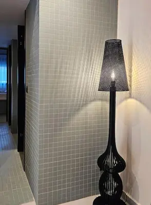 a lamp in a bathroom with a tiled wall at MINT in Rhodes Town
