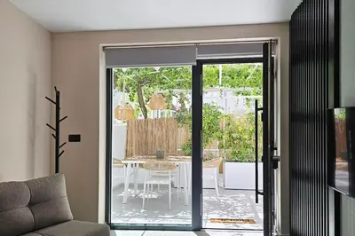 a living room with a glass door leading to a patio at MINT in Rhodes Town
