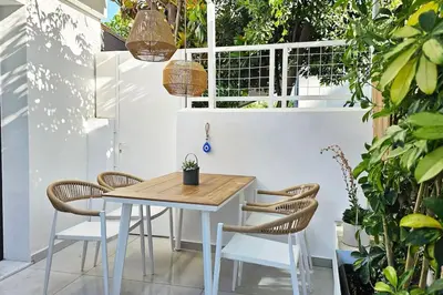 a table and chairs on a patio with plants at MINT in Rhodes Town