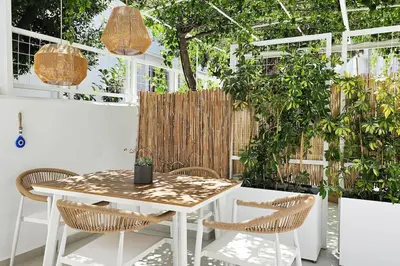 a patio with a table and chairs and a greenhouse at MINT in Rhodes Town