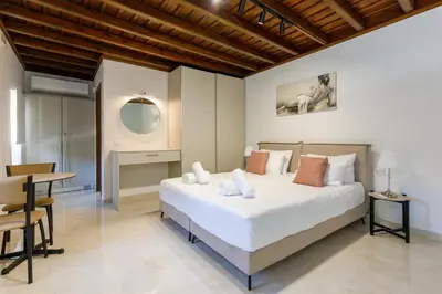a bedroom with a large bed and a desk at Lindian Villas in Líndos