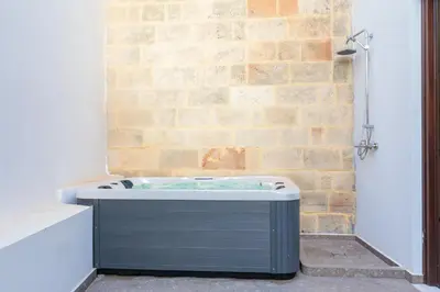 a bath tub sitting next to a brick wall at Lindian Villas in Líndos