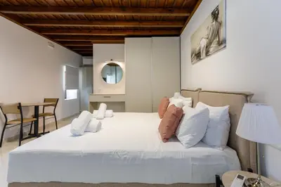 a bedroom with a large white bed with white pillows at Lindian Villas in Líndos