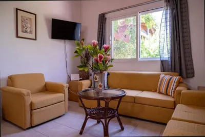 a living room with a couch and chairs and a table at Ibiscus Cottage in Paradisi near the Beach in Paradeísion
