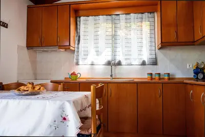 a kitchen with a table and a sink and a window at Ibiscus Cottage in Paradisi near the Beach in Paradeísion