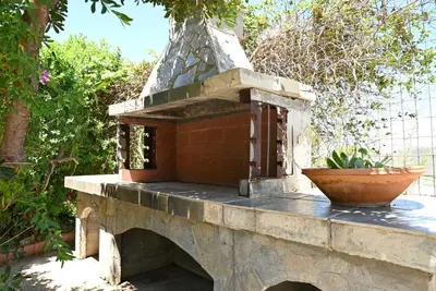 a bird house sitting on top of a stone wall at Ibiscus Cottage in Paradisi near the Beach in Paradeísion