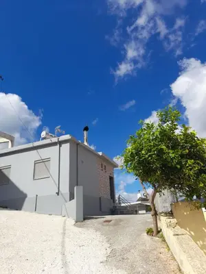 a white building with a tree next to it at Isaias house in Rhodes Town