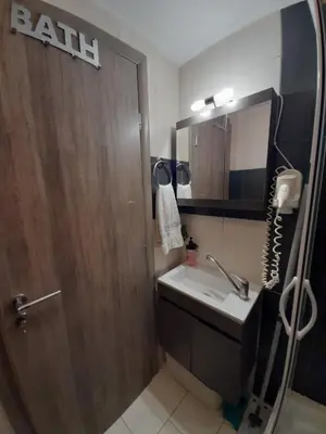 a bathroom with a wooden door and a sink at Isaias house in Rhodes Town